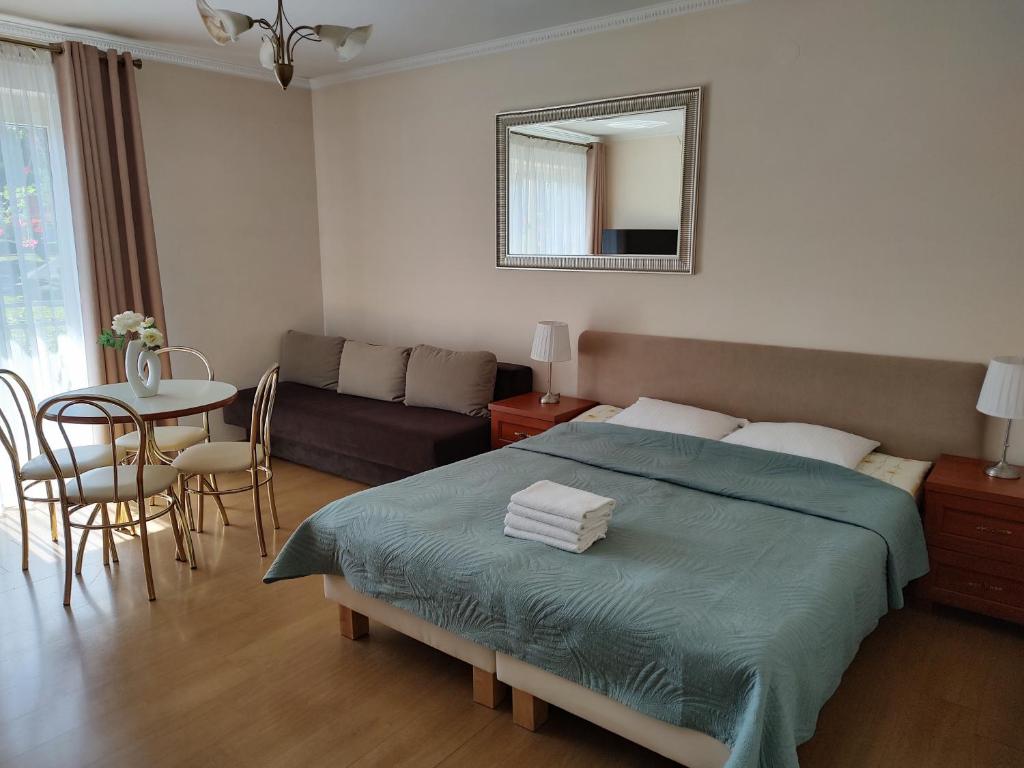 1 dormitorio con cama, mesa y sofá en Pokoje Aleksandra, en Władysławowo