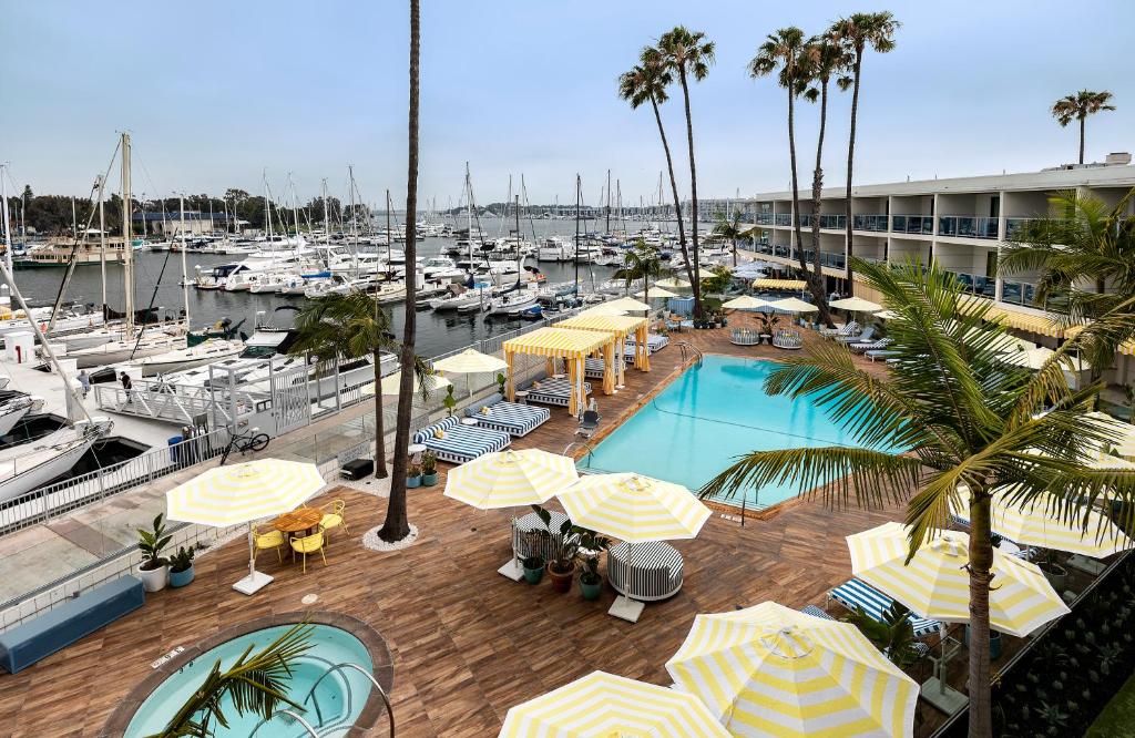 a swimming pool with umbrellas and a marina with boats at Marina del Rey Hotel in Los Angeles