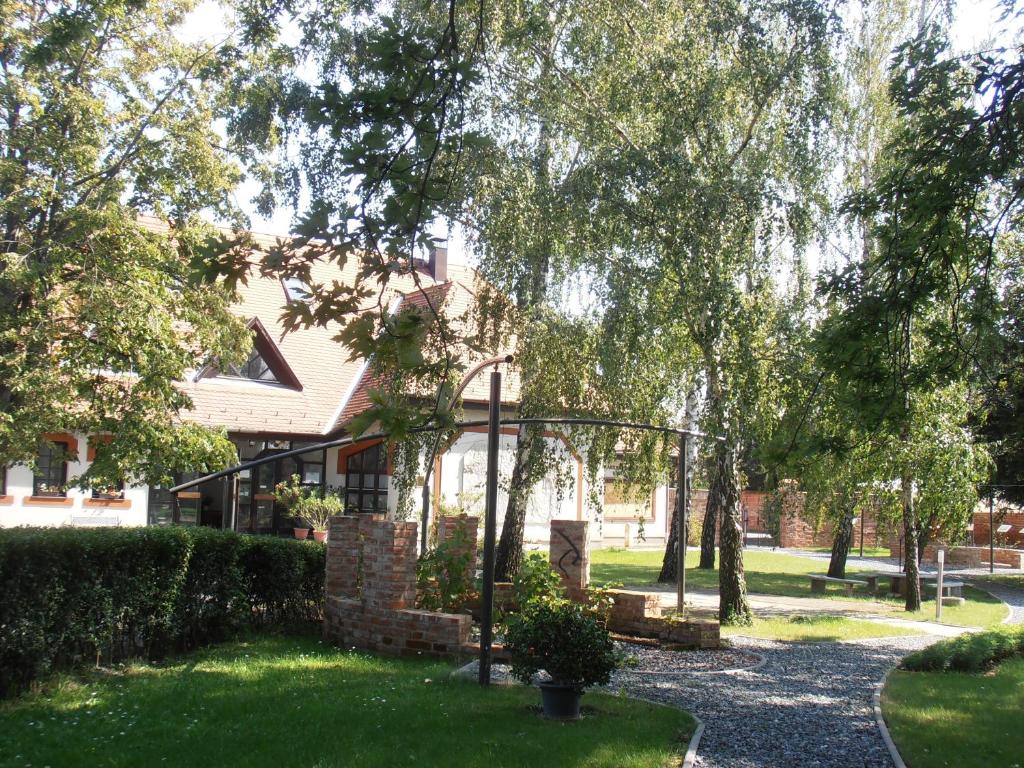 dom z ogródkiem z zieloną trawą i drzewami w obiekcie Martineum Felnőttképző Akadémia w mieście Szombathely
