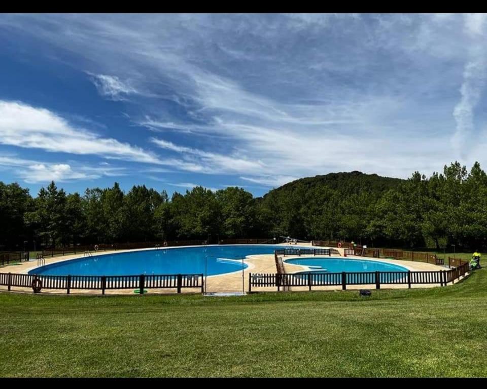 une grande piscine bleue entourée d'une clôture. dans l'établissement El rincón de los Lanchares, à Sotillo de la Adrada