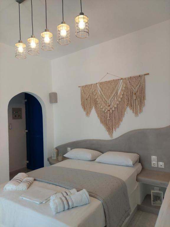 a bedroom with two beds in a room with lights at Anemelia Hotel Adamas in Adamantas