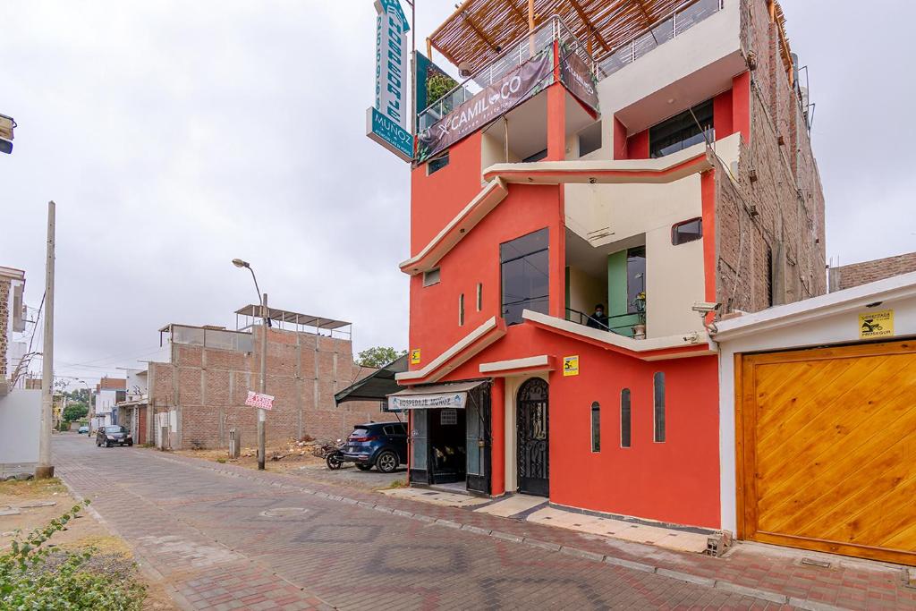 un edificio rosso sul lato di una strada di Ayenda Muñoz a Ica