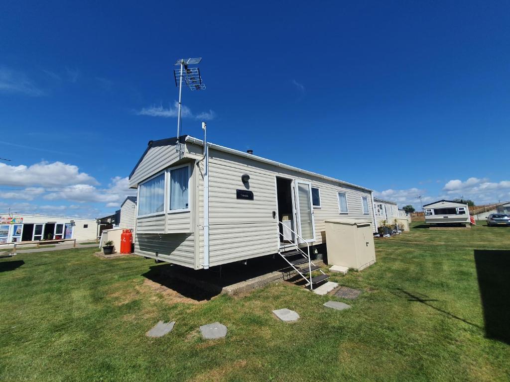a tiny house sitting on top of a grass field at Remarkable 5-Bed Cabin in Clacton-on-Sea in Clacton-on-Sea