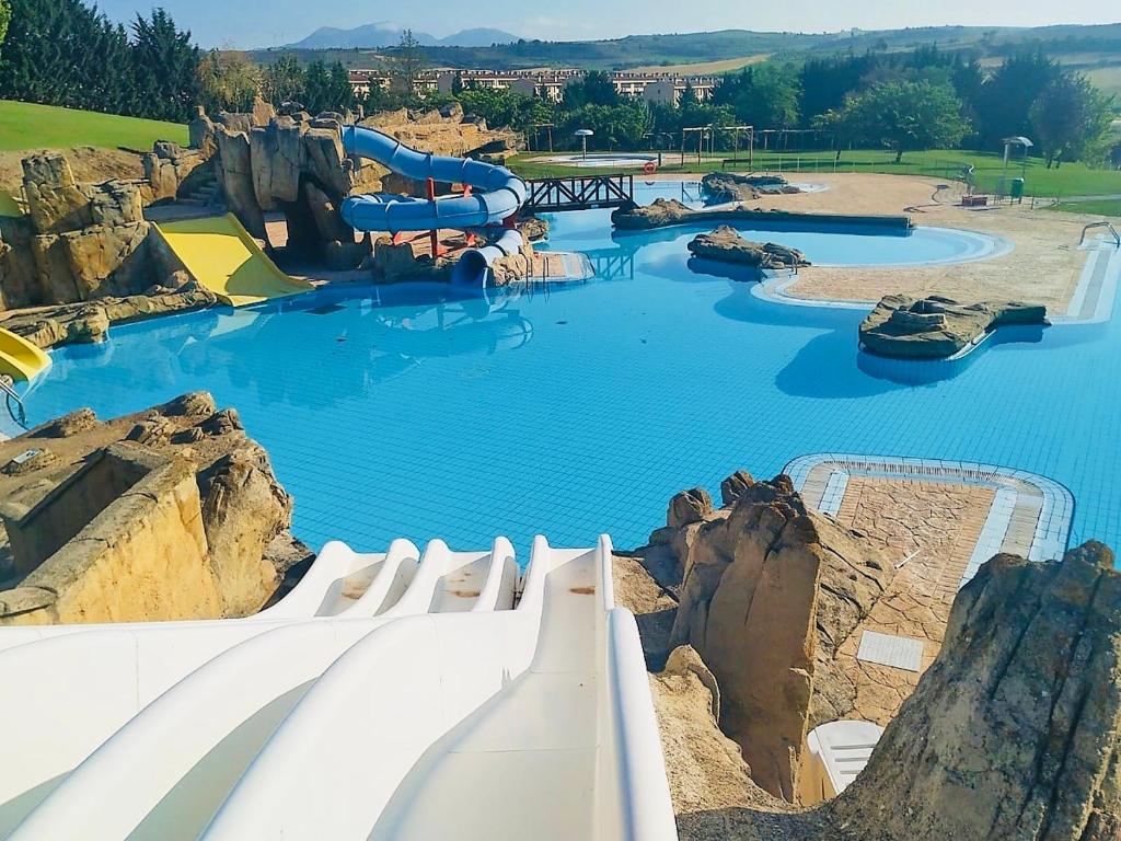 een waterglijbaan in een waterpark met blauw water bij La Puerta de Viana, con desayuno, piscina y posibilidad Visita a bodega! in Viana