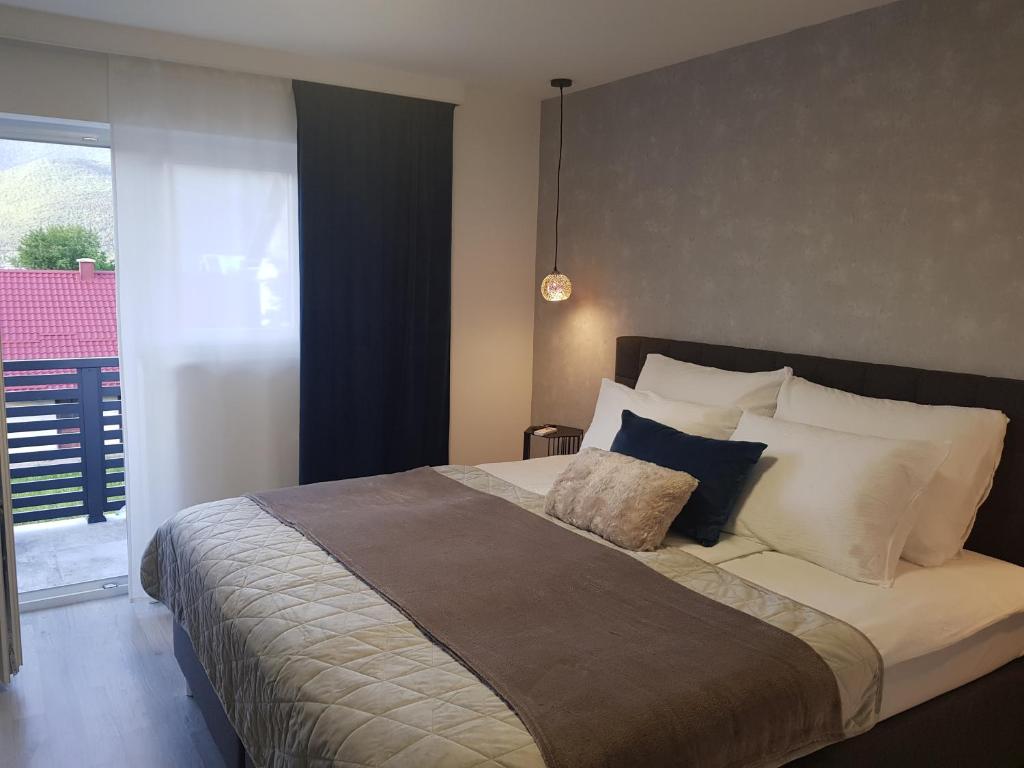 1 dormitorio con 1 cama grande con almohadas blancas en Rooms Vanteo, en Korenica