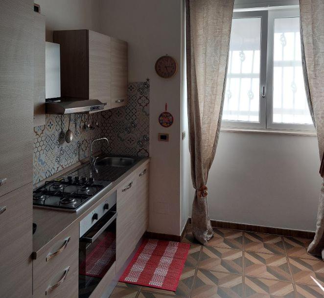 a kitchen with a stove and a sink and a window at Mivigio in Bari