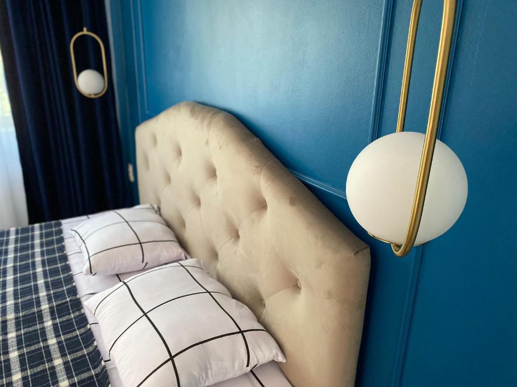 a bedroom with a bed and a blue wall at Glam Boutique in Mangalia