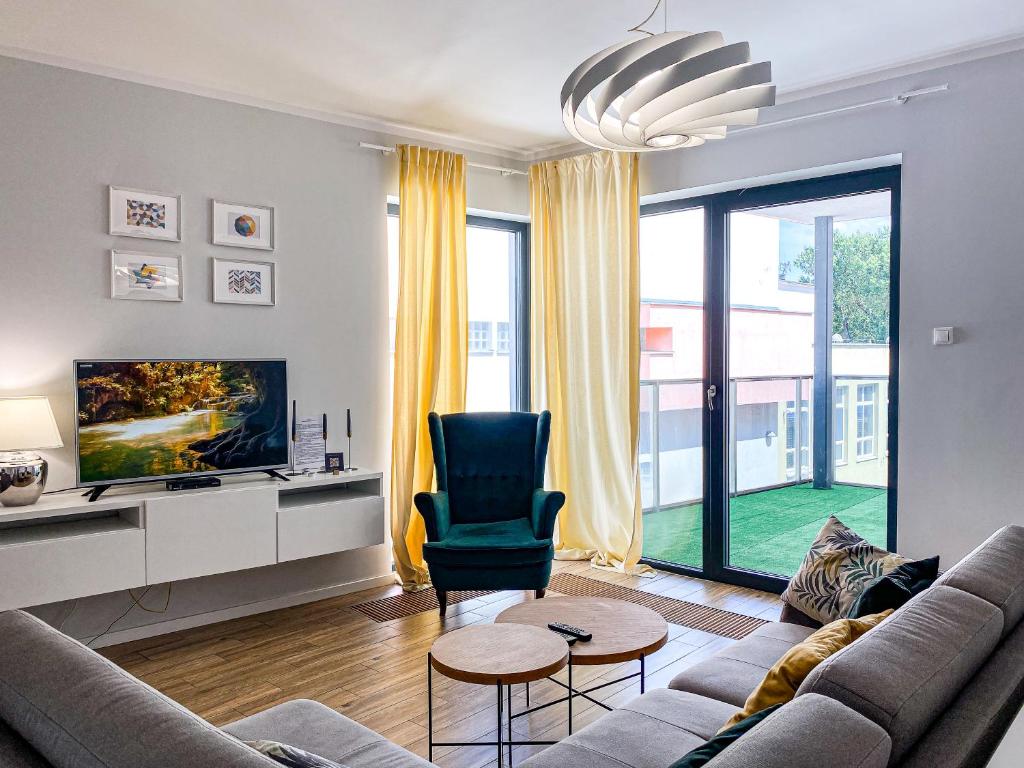 uma sala de estar com um sofá e uma cadeira em BP I Premium em Toruń