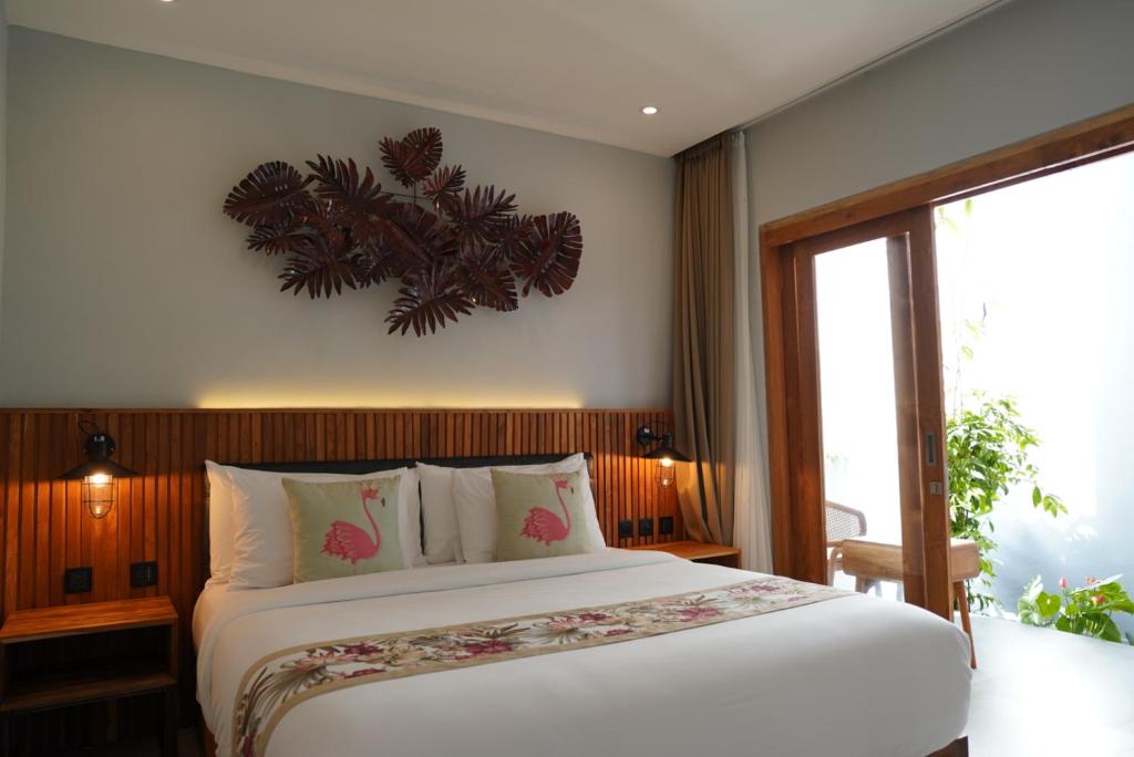 a bedroom with a large bed and a large window at Umah Anyar in Canggu