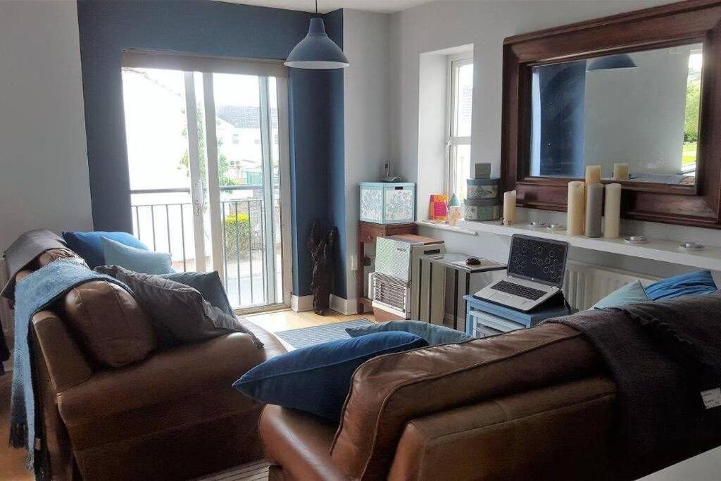 una sala de estar con 2 sofás y un ordenador portátil sobre una mesa en Galway City Lovely 2 Bed Apartment en Galway