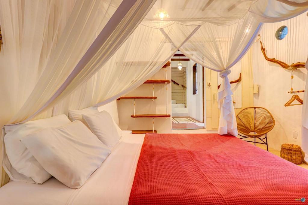 a bedroom with a bed with a canopy at Pousada Ilha Verde in Itacaré