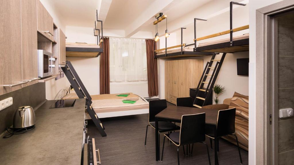 プラハにあるFlying Bed Apartment close to Prague Castle and Airportの小さな客室で、ダイニングテーブル、二段ベッドが備わります。