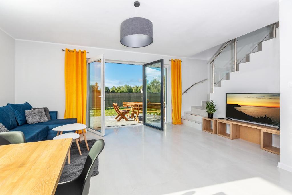 a living room with a blue couch and a tv at Osada Nord domki wypoczynkowe in Jastrzębia Góra