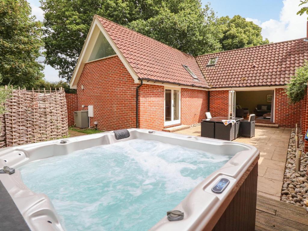 a hot tub in the backyard of a house at Oak Tree Lodge in Rackheath