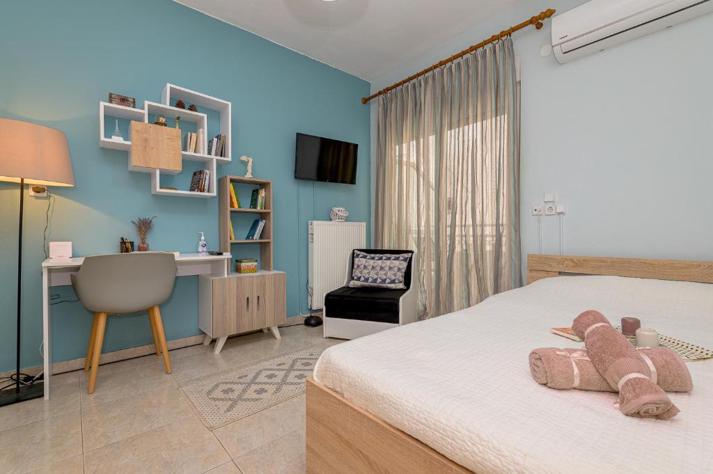 a bedroom with a bed with a desk and a chair at Melody Apartment in Néa Khilí