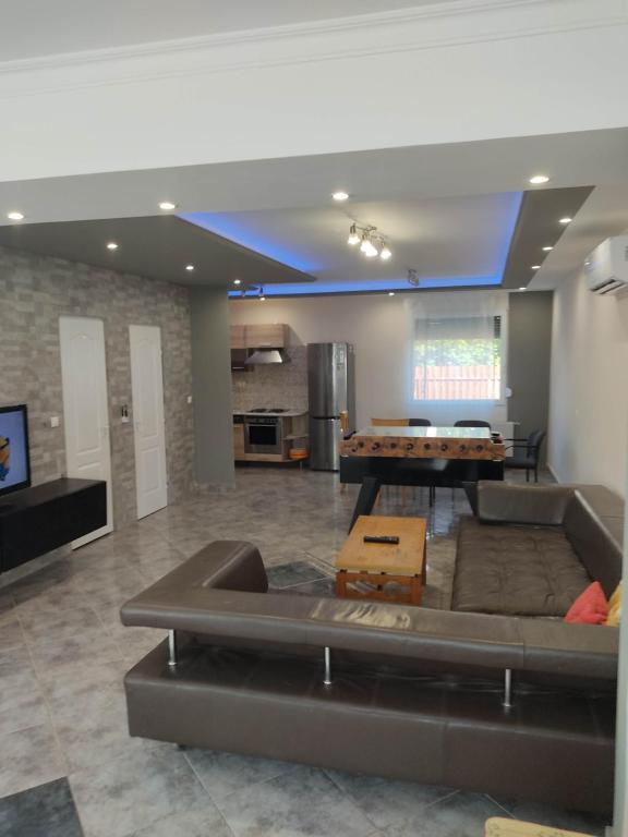 a living room with a couch and a table at Nurmi House in Hajdúszoboszló