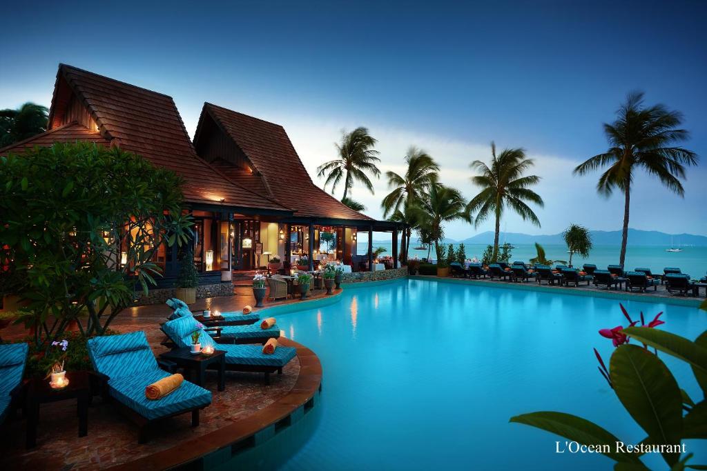 una piscina con sillas y un edificio en Bo Phut Resort and Spa - SHA Plus, en Bophut 