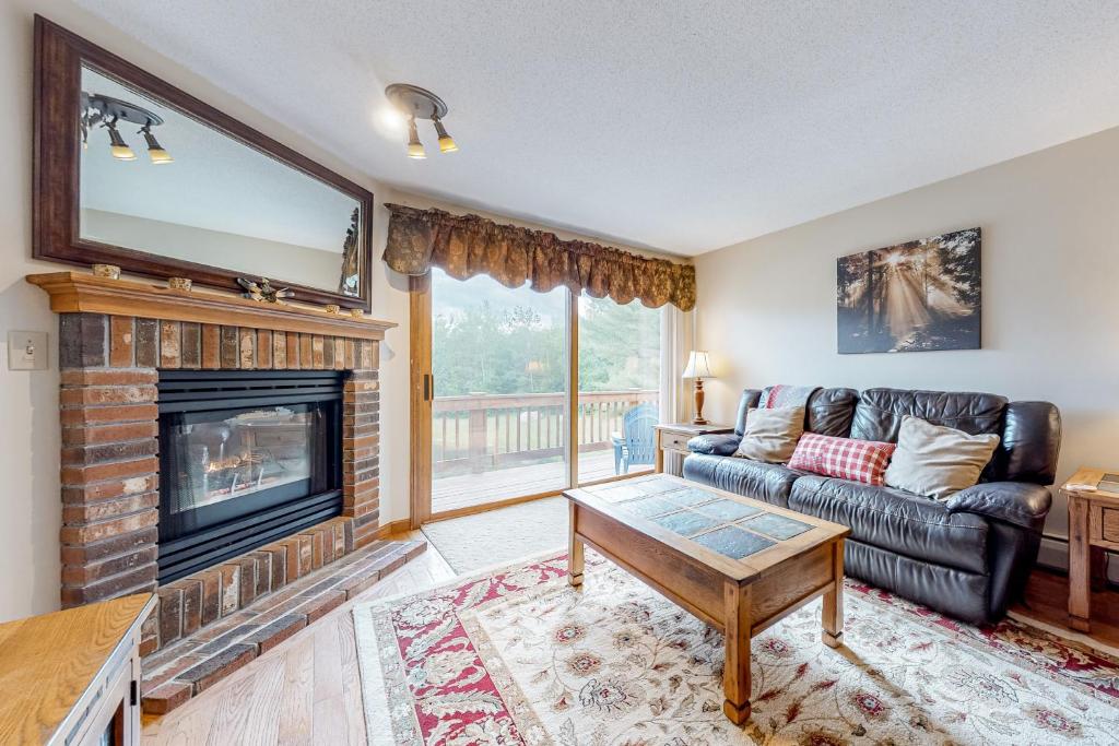 a living room with a couch and a fireplace at White Mountain Retreat in Lincoln