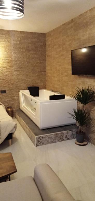 duża biała wanna w pokoju z kanapą w obiekcie ESTUDIO Jacuzzi SOL De JEREZ w mieście Jerez de la Frontera