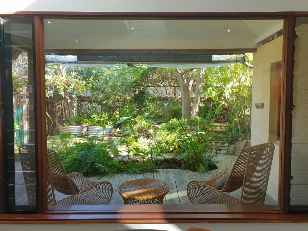a view of a garden through a window at The Sanctuary - garden oasis in South Fremantle in South Fremantle