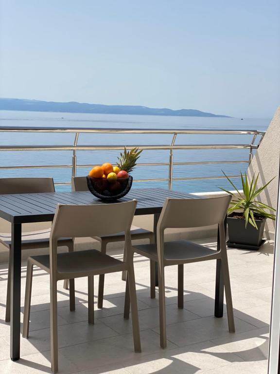 d'une table et de chaises avec un bol de fruits sur le balcon. dans l'établissement Luxury Penthouse Adriatic Blue - On the beach, à Tučepi