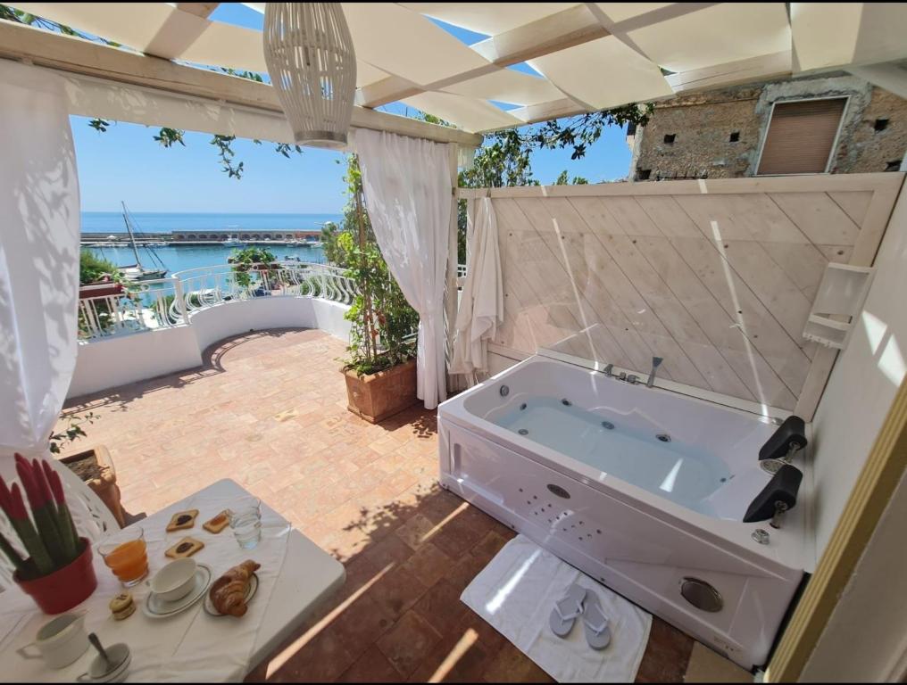 uma grande casa de banho com banheira num pátio em luxury B&B e FAMILY RESIDENCE VILLA FILOMENA em Marina di Camerota
