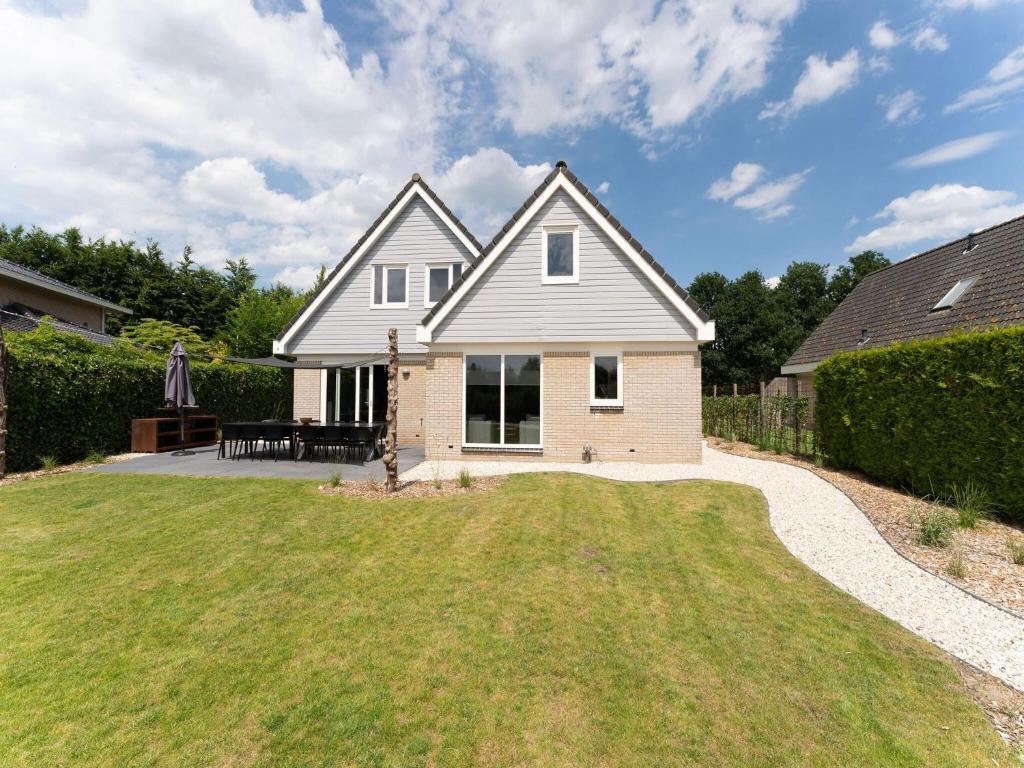 a house with a grassy yard in front of it at Lavish villa in Zeewolde with sauna in Zeewolde