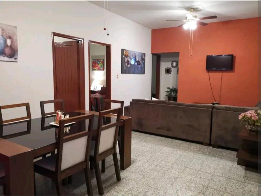 uma sala de estar com um sofá, uma mesa e cadeiras em Cómodo departamento em Papantla de Olarte