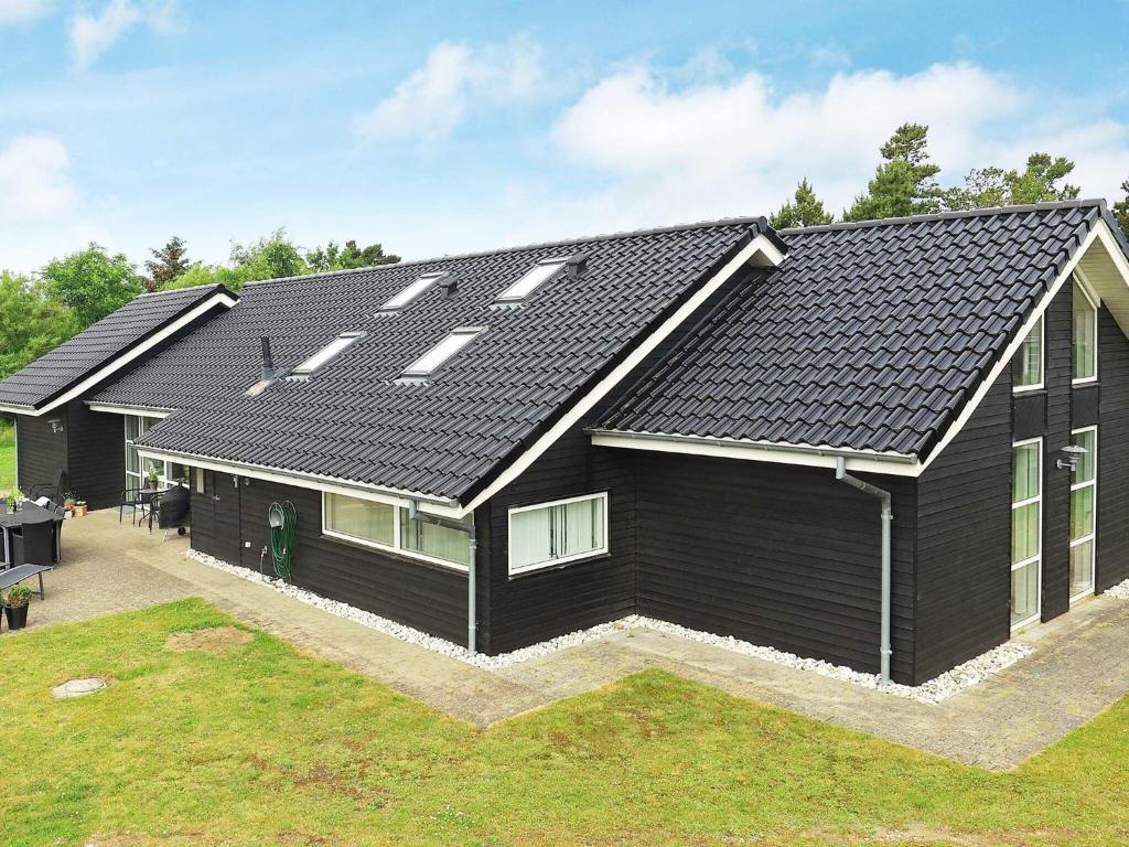 ブラーバンドにあるFour-Bedroom Holiday home in Blåvand 24の太陽電池パネル付黒屋根