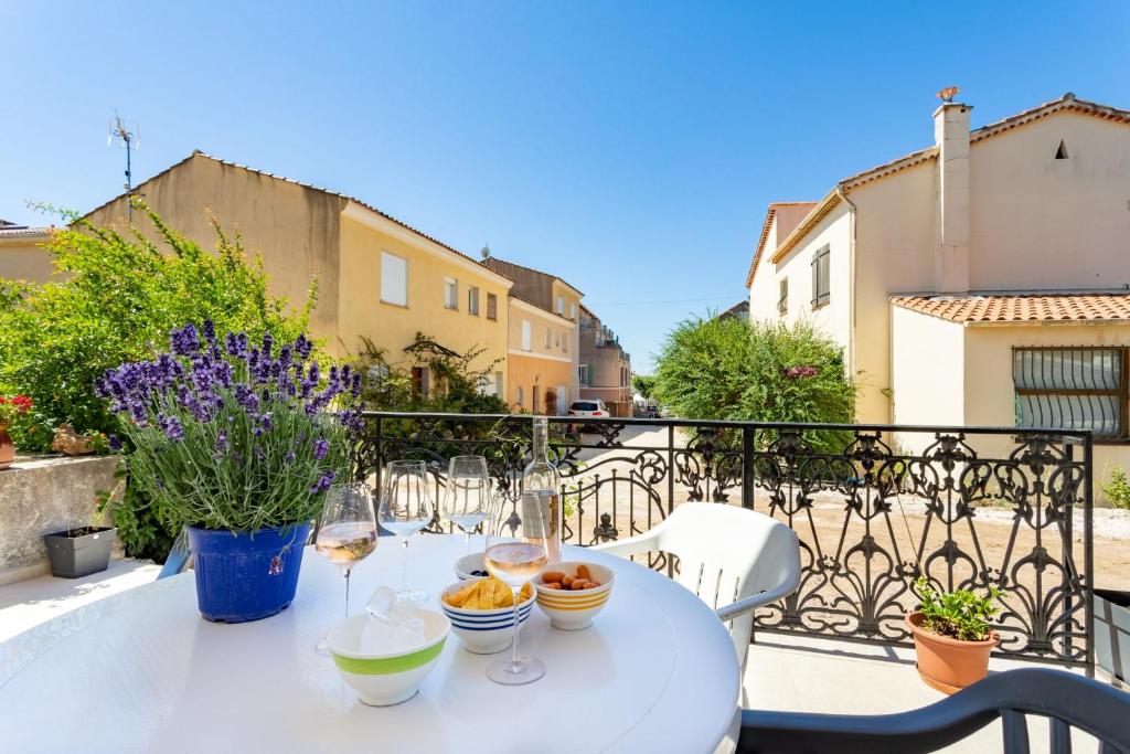 - une table blanche avec des verres à vin sur le balcon dans l'établissement Luxurious 1 bedroom, AC, terrace, close beaches - Dodo et Tartine, à Carqueiranne