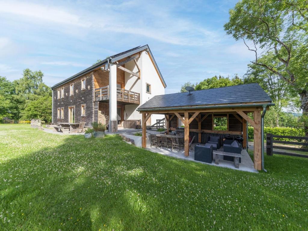 een groot huis met een tuinhuisje in de tuin bij Spacious villa in Freyneux with garden in Freineux