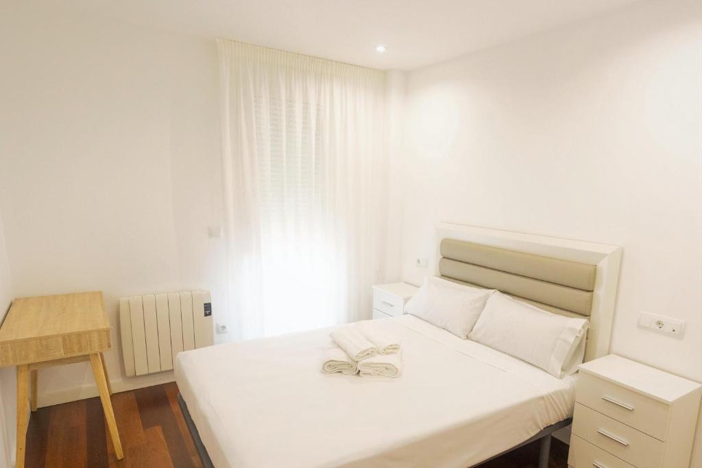1 dormitorio con cama blanca con arco en Mercado Cee Galitrips Apartment, en Cee
