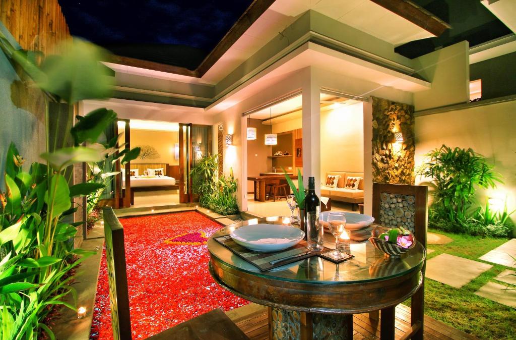 een eetkamer met een tafel en een rood tapijt bij Maharaja Villas Bali - CHSE Certified in Kerobokan