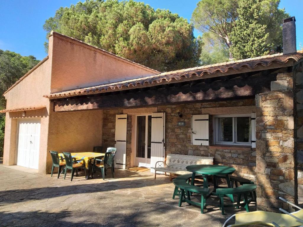 un patio avec une table et des chaises et un bâtiment dans l'établissement Charming gites in Lavandou walking distance to beach, au Lavandou