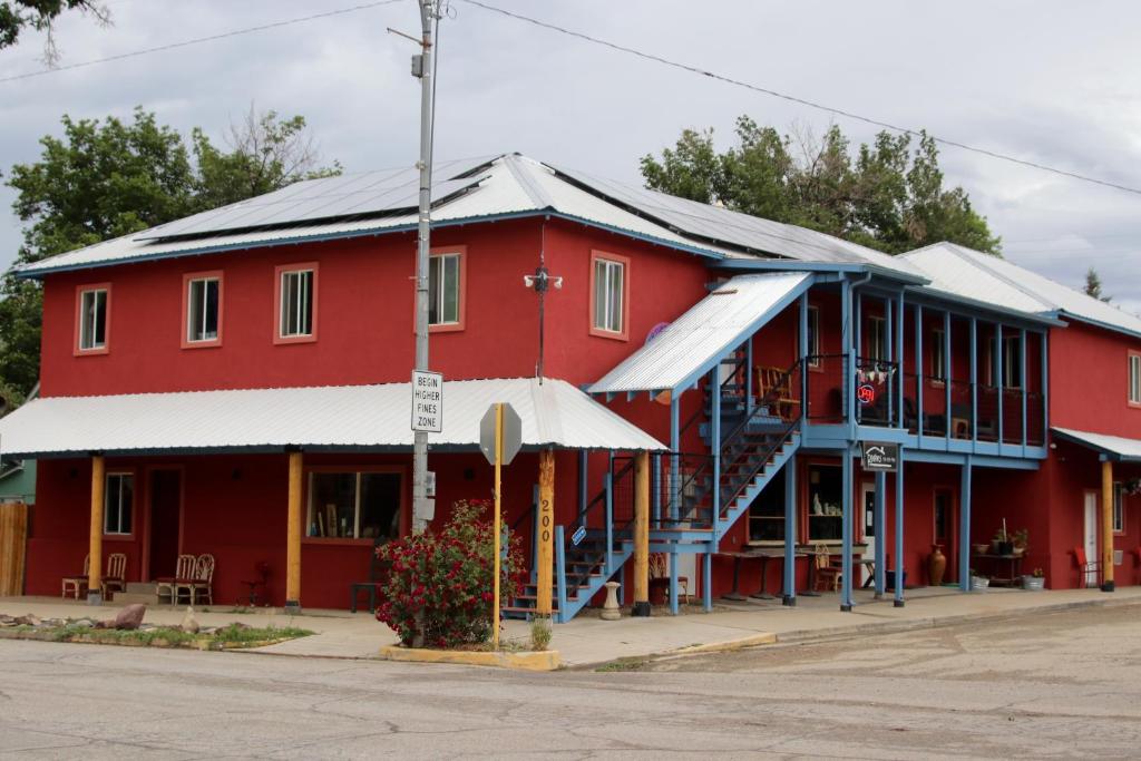 un bâtiment rouge avec des panneaux solaires dans une rue dans l'établissement Mancos Inn, à Mancos