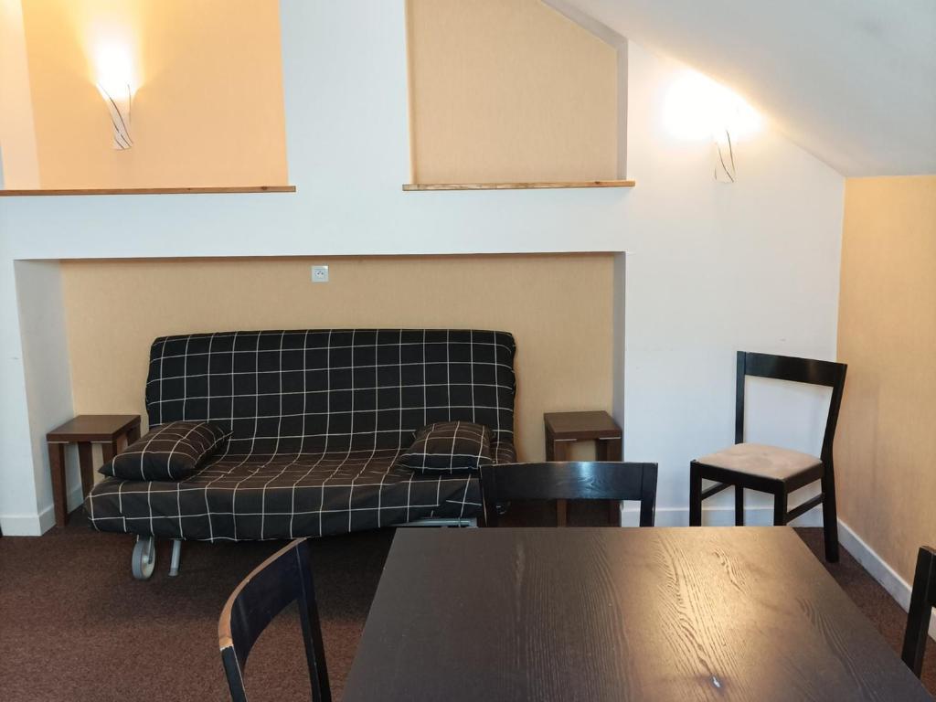 ein Sofa in einem Zimmer mit 2 Stühlen und einem Tisch in der Unterkunft Appartement Jausiers, 3 pièces, 6 personnes - FR-1-165B-28 in Jausiers
