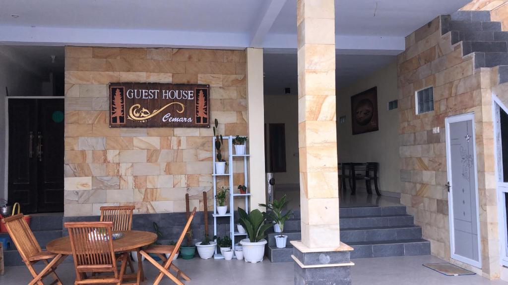 um restaurante com mesa e cadeiras e uma placa em Guest house Cemara em Pasuruan