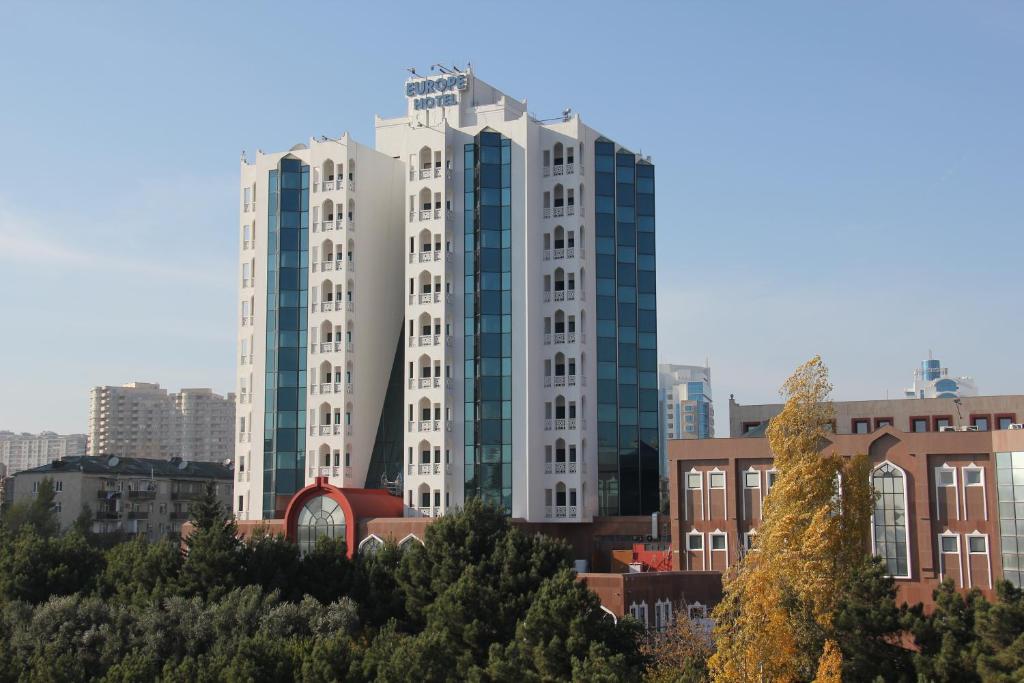 a tall white building in the middle of a city at Grand Hotel Europe in Baku