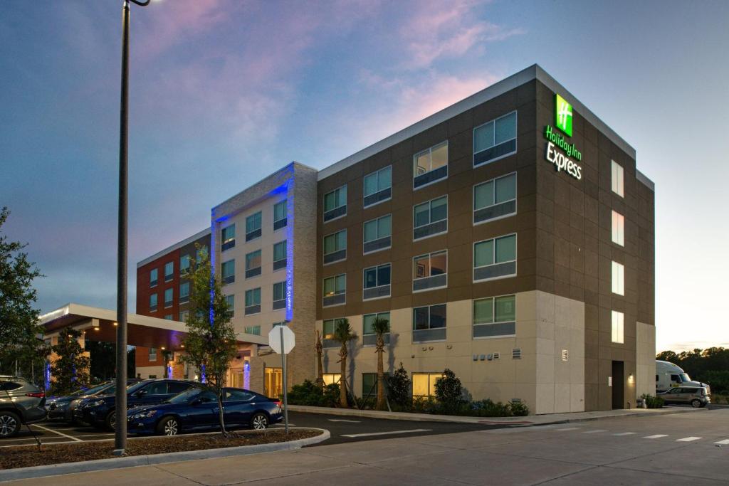 um edifício de hotel com um sinal verde em Holiday Inn Express Orlando - South Park, an IHG Hotel em Orlando