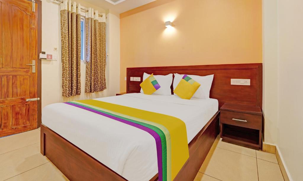 Kattappana的住宿－Itsy By Treebo - Sparrows Suite & Resorts With Mountain View，一间卧室配有一张大床,提供白色床单和色彩缤纷的枕头