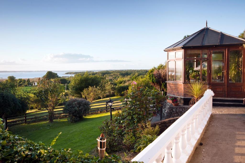 a small house with a white fence and a balcony at Shannonview Self Catering in Ballinderry