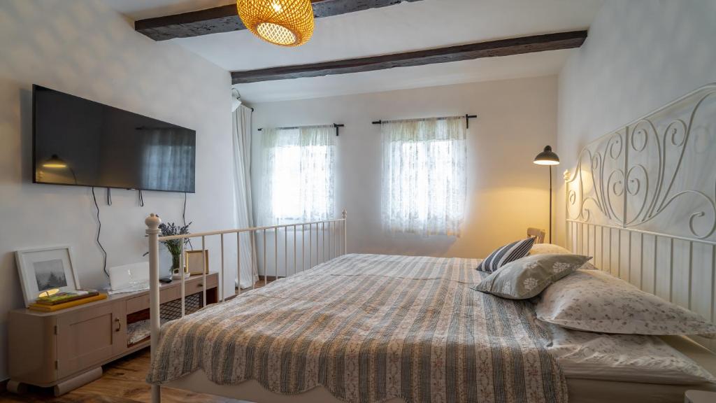 a bedroom with a large bed and a flat screen tv at Mala kuća in Vele Drage