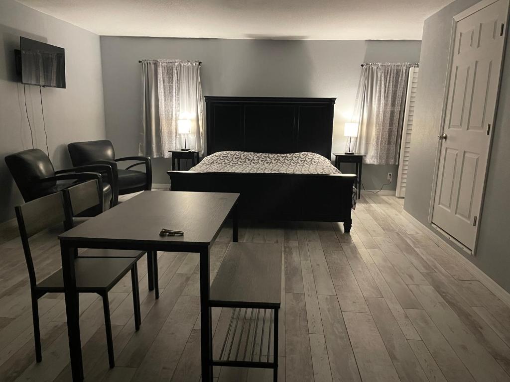 1 dormitorio con 1 cama, mesa y sillas en Maria’s, en Auburndale