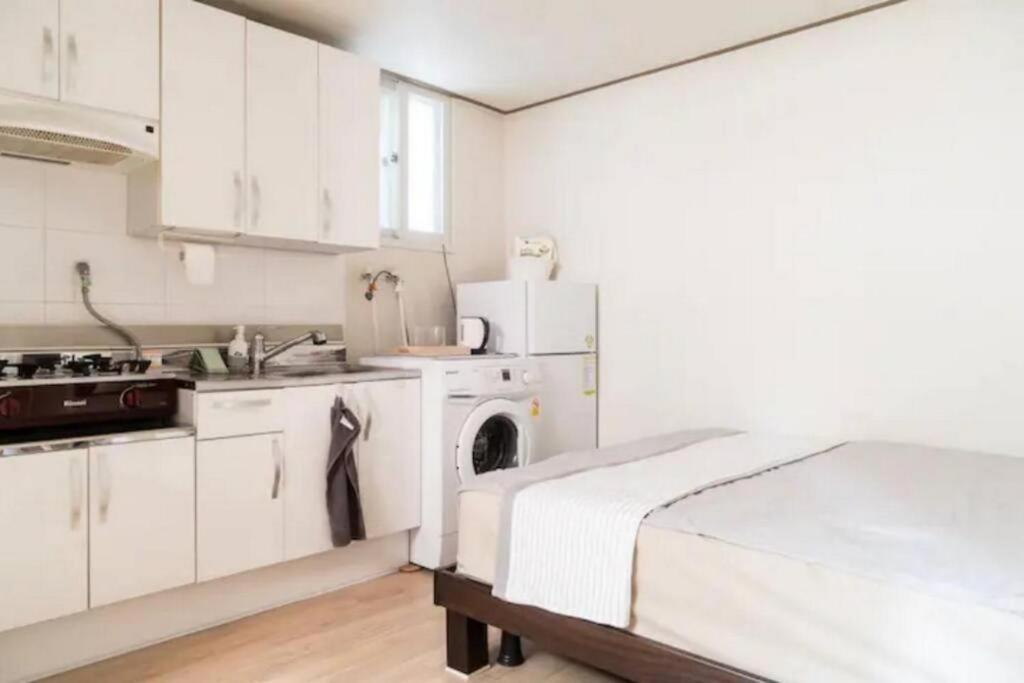 a kitchen with white cabinets and a washer and dryer at Seoul Central Namsan Studio #103 in Seoul
