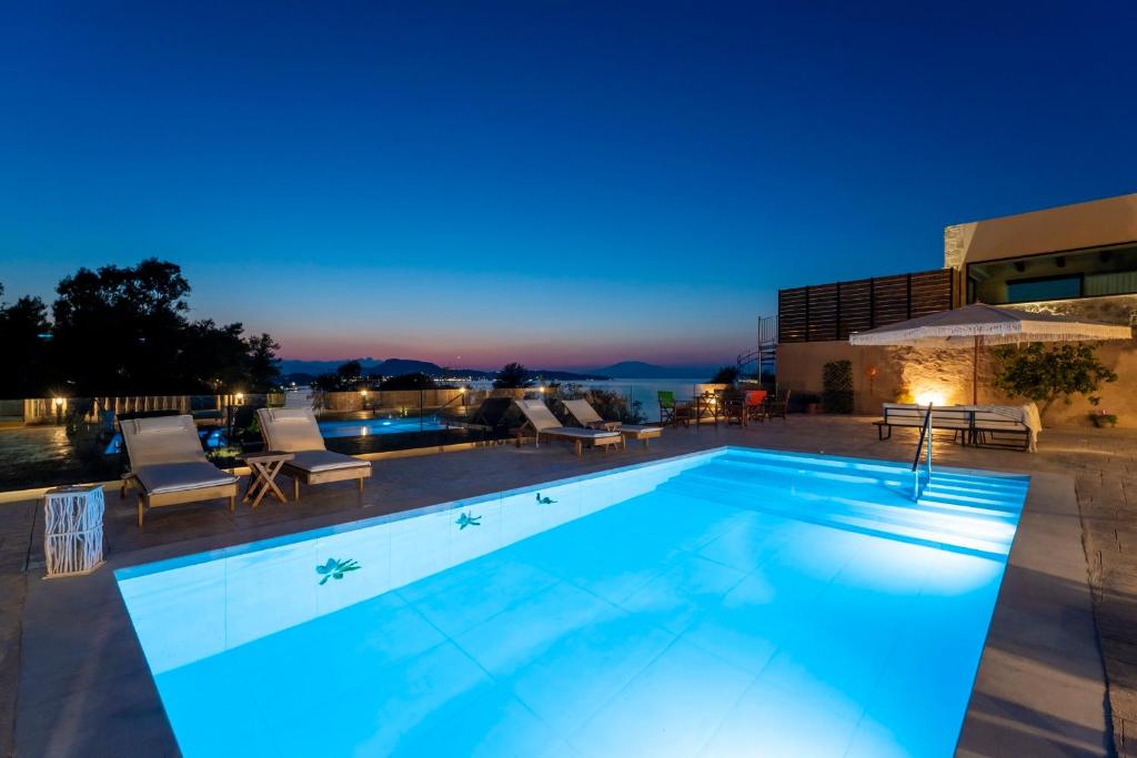 a swimming pool at night with a hotel at Villa Vicky in Zakynthos Town