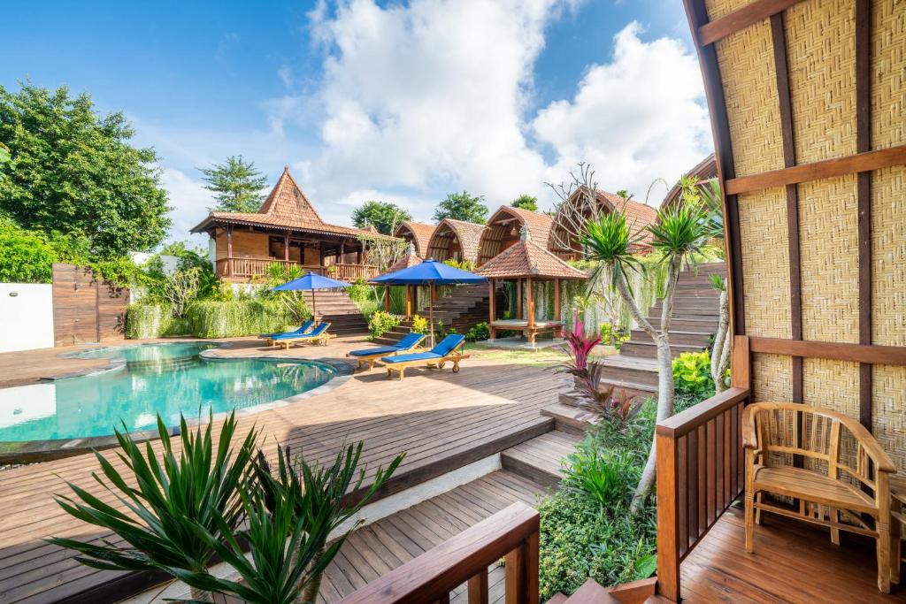 a house with a swimming pool and a wooden deck at Lumbung Sari in Uluwatu