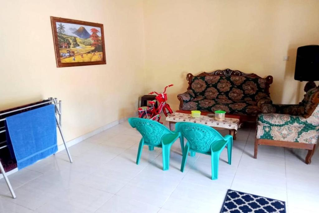 Karbang的住宿－SPOT ON 91371 Wisma Nadira，客厅配有沙发和桌椅