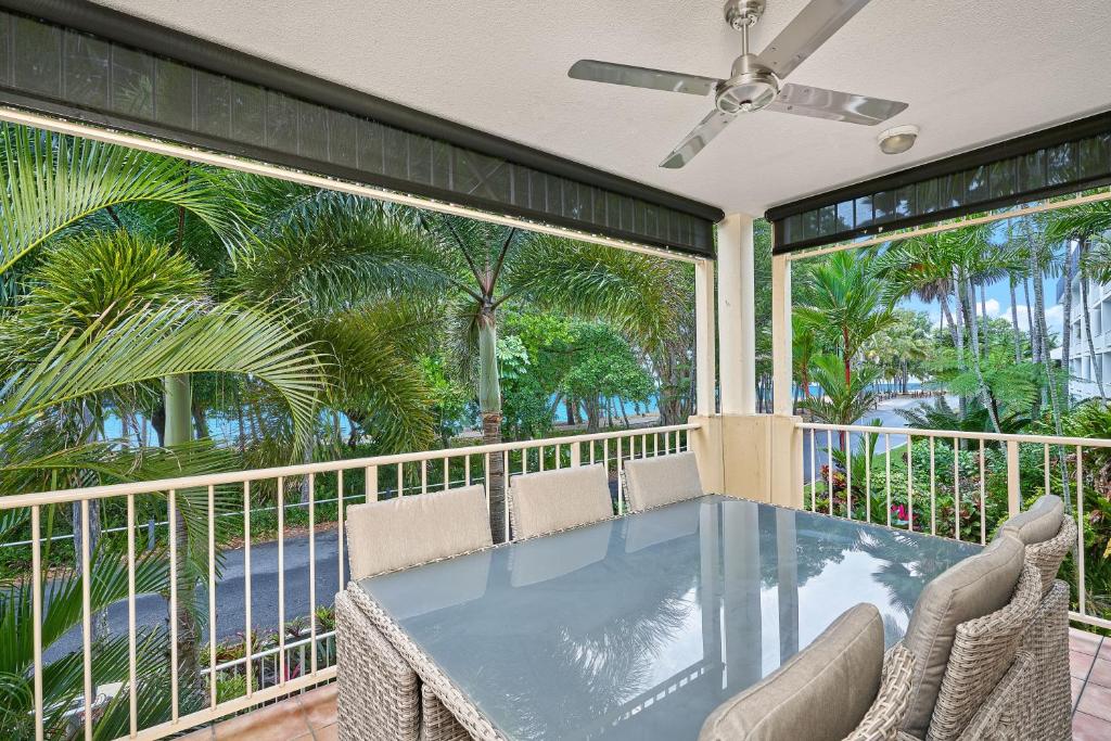 een balkon met een tafel en stoelen en palmbomen bij Beachfront On Arlington in Clifton Beach