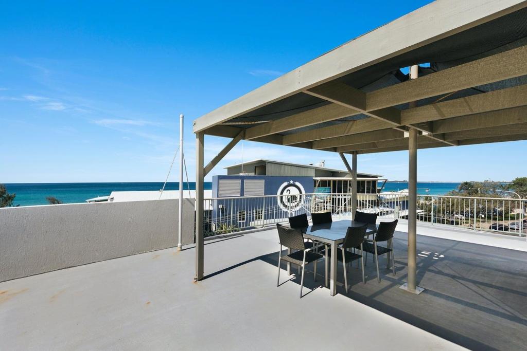 a patio with a table and chairs on a roof at Beachfront penthouse in Maroochydore