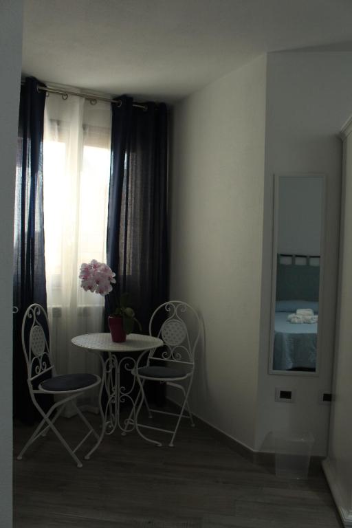 um quarto com uma mesa e cadeiras e uma janela em B&B il Melograno em Paulilatino